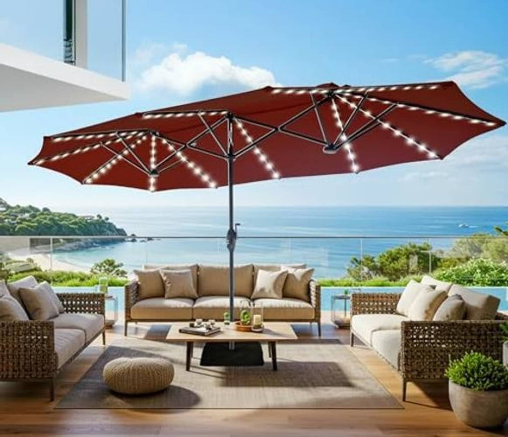 Burgundy patio umbrella with warm solar string lights across the canopy and pole.