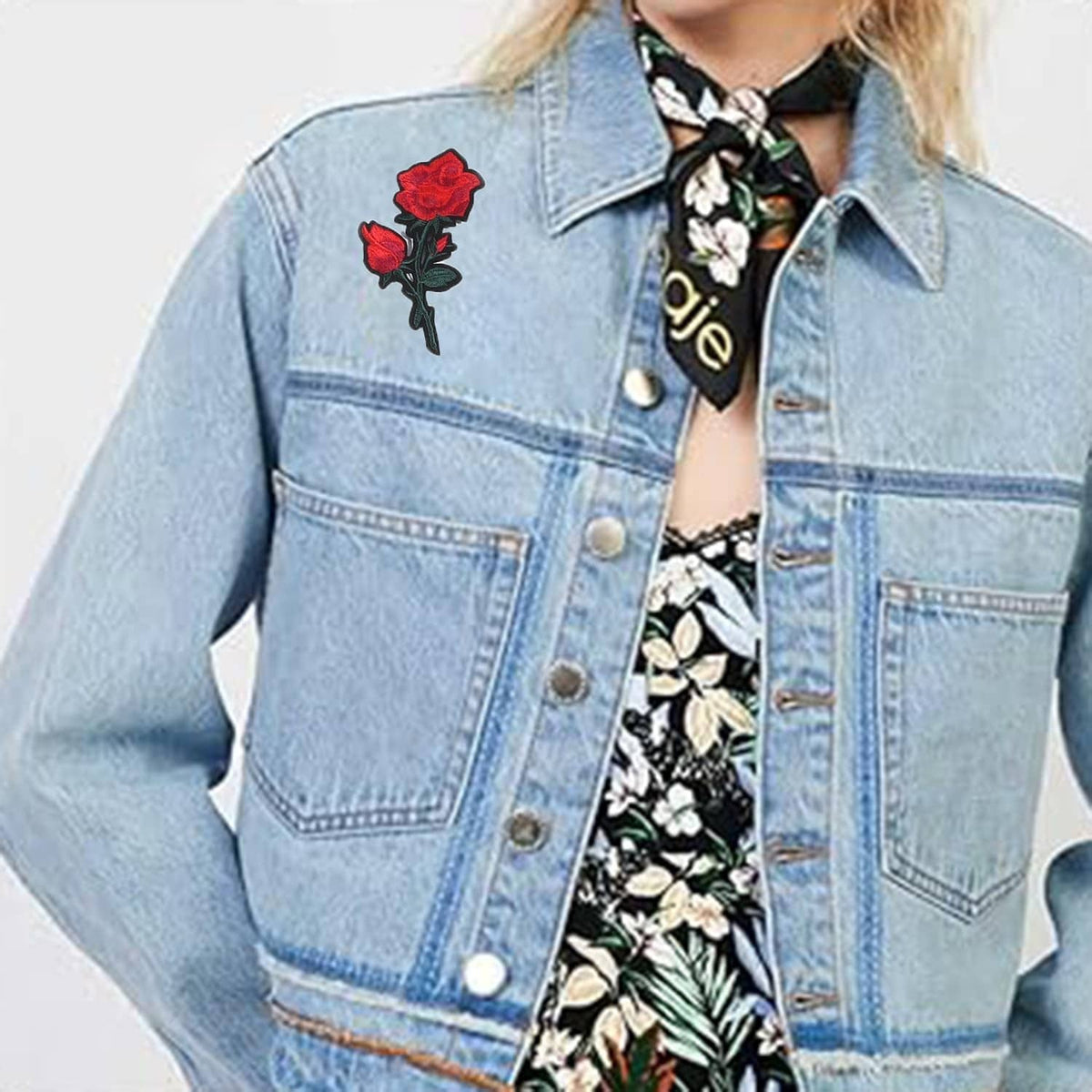 Light blue denim jacket with small embroidered red rose patch near the chest
