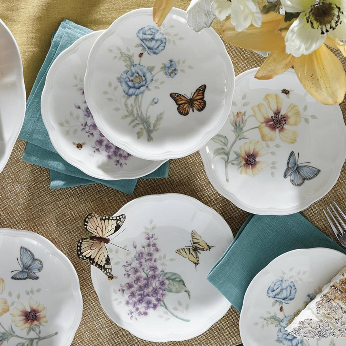 Close-up of round tidbit plates featuring butterflies and flowers on white porcelain