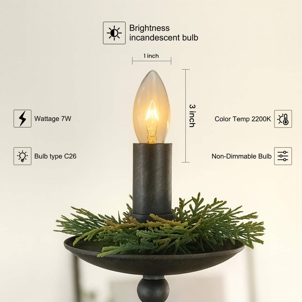 Clear C26 incandescent bulb with golden screw base on dark candleholder with greenery