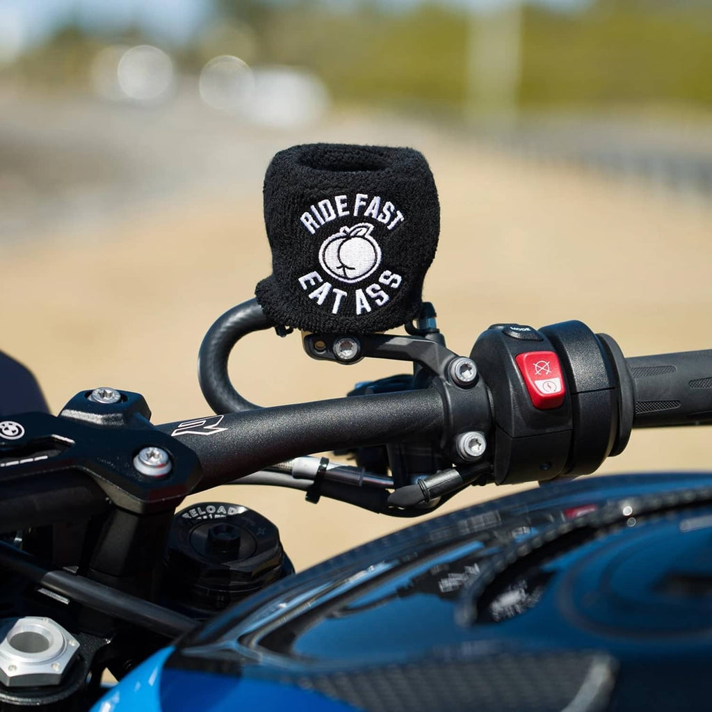 Black brake fluid reservoir cover sock with “RIDE FAST EAT ASS” logo on handlebars