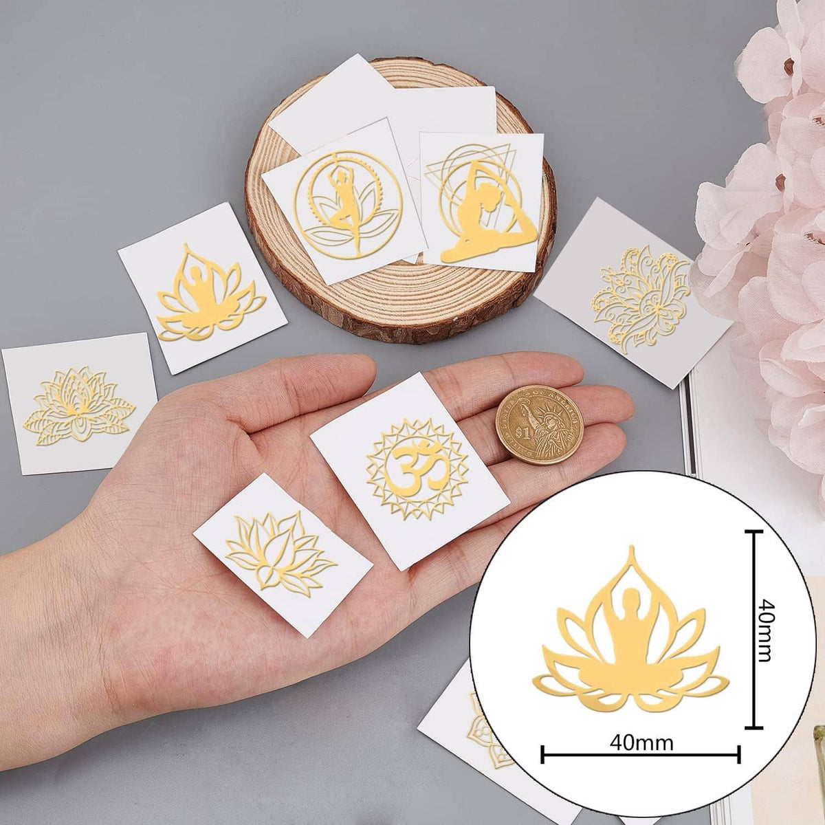 Small gold chakra yoga stickers held in hand, showing lotus and Om designs