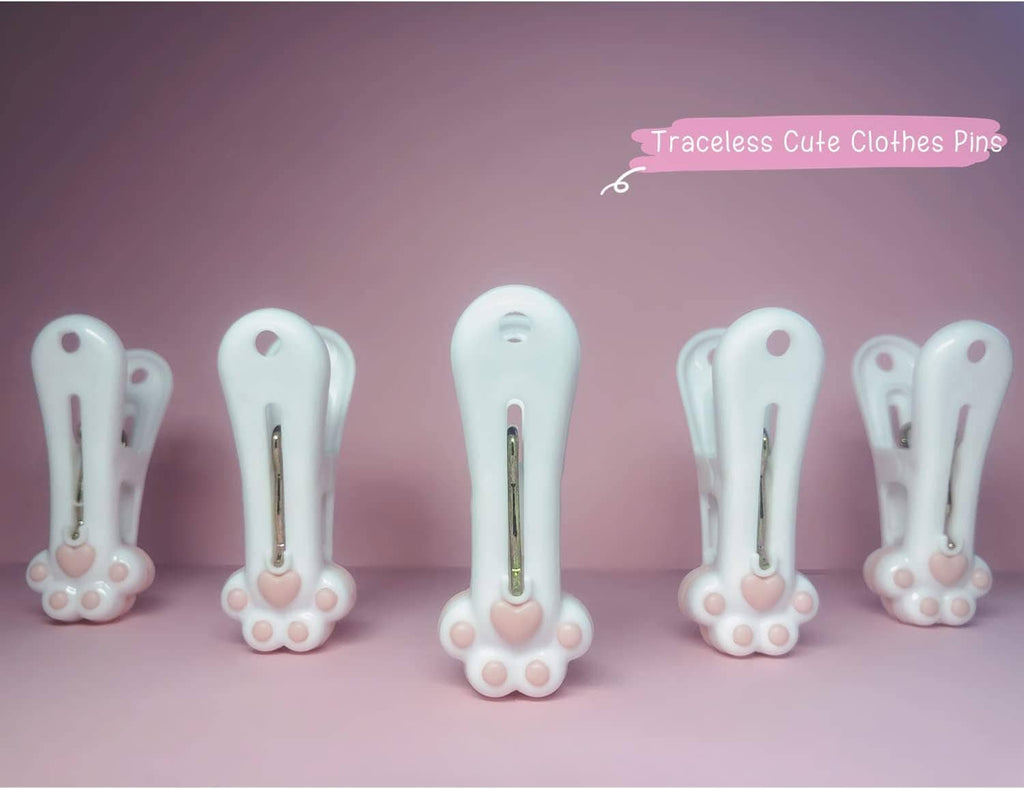 Cluster of white paw-decor plastic clothespins with metal springs