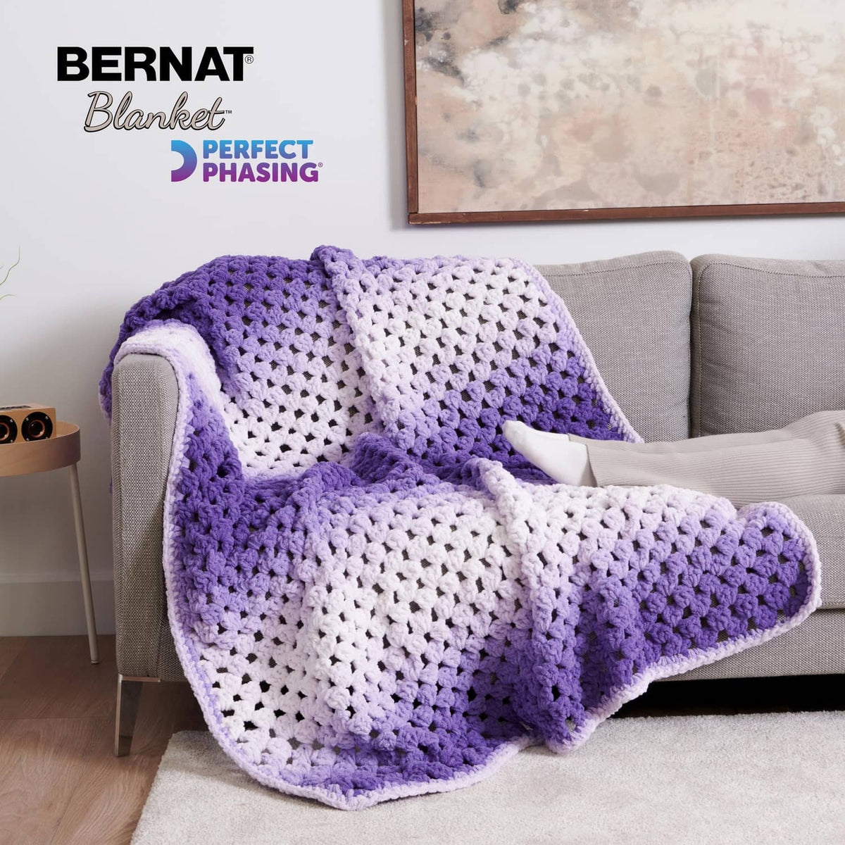 Crocheted throw blanket with purple and white ombre blocks and scalloped edge
