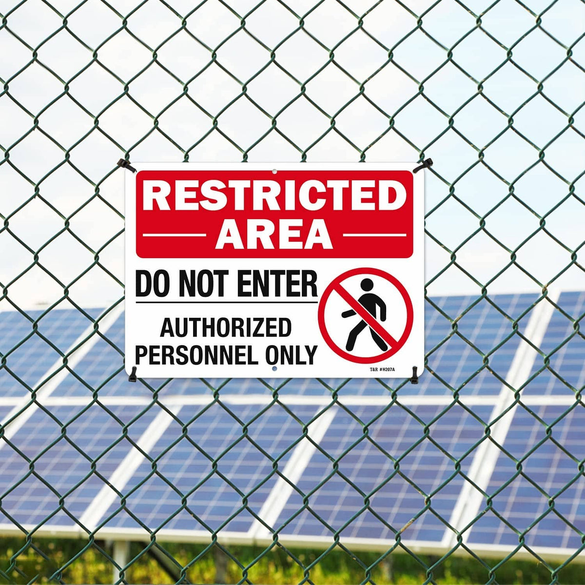 Red restricted area sign attached to chain-link fence with black mounting posts