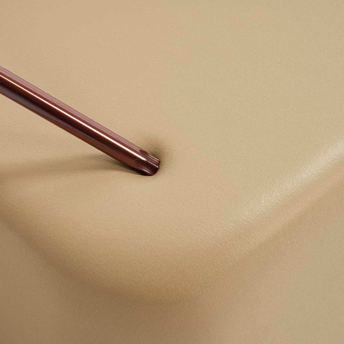 Tan seat cushion vinyl with visible seam and smooth, even texture