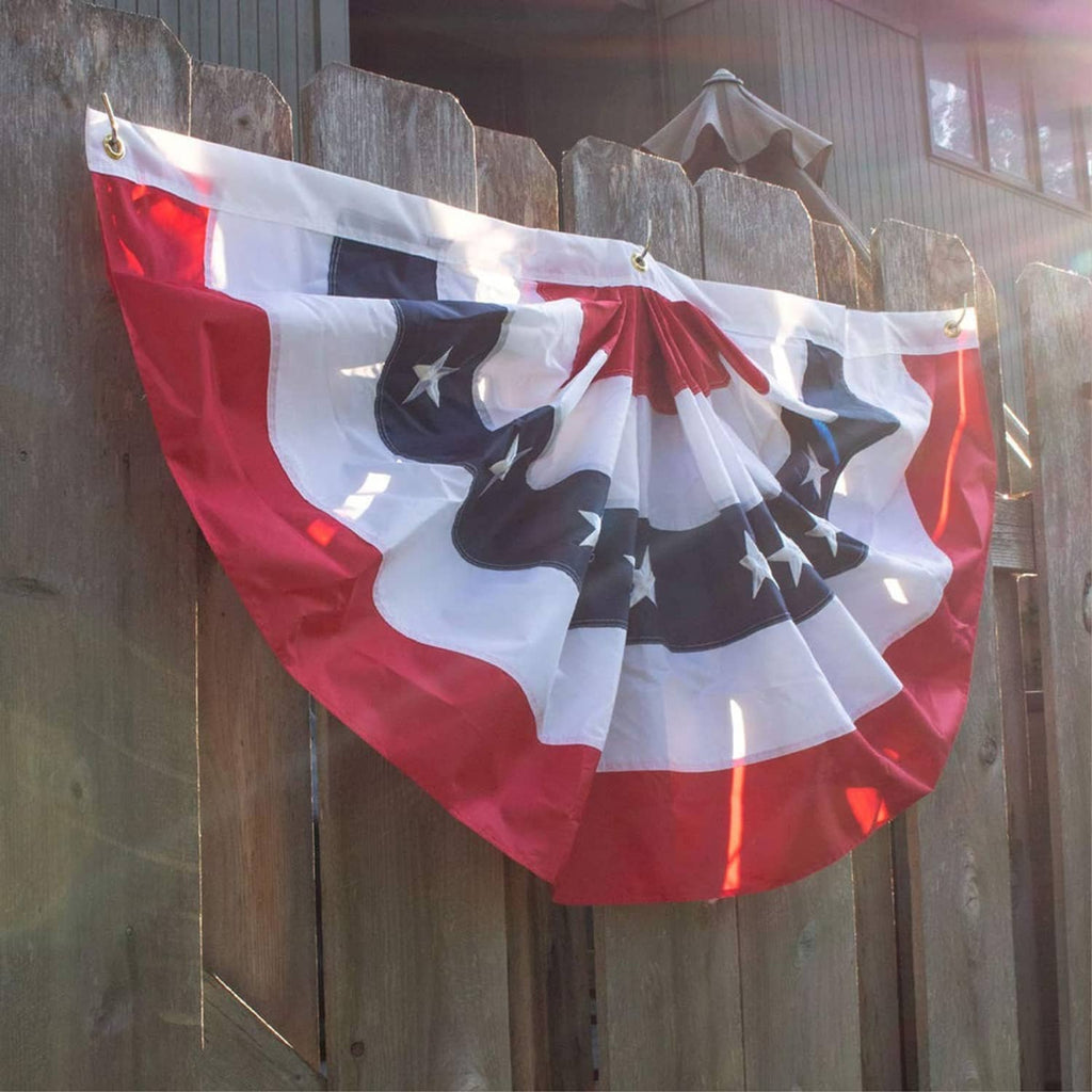 Patriotic pleated fan bunting flags on outdoor fence, red white and navy star panels