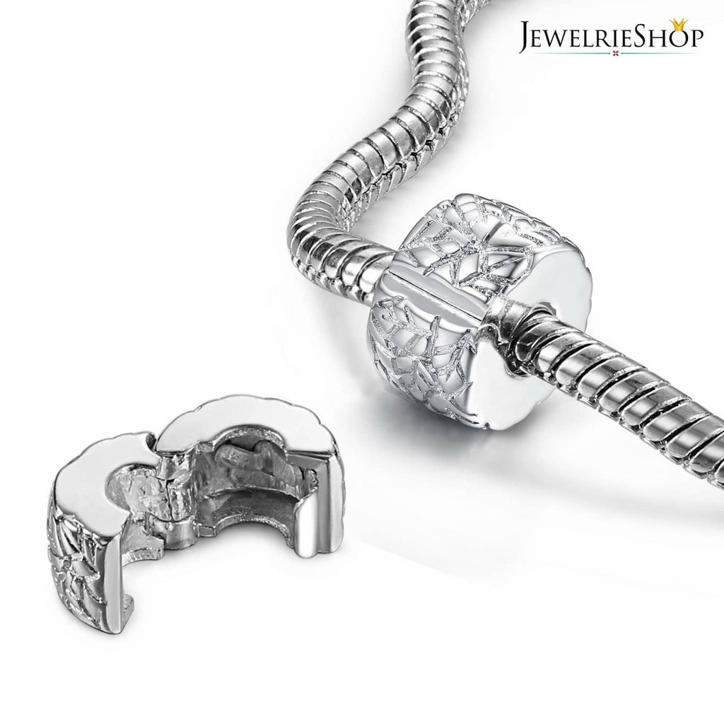 Silver round clip spacer charm bead with cutout pattern, shown near bracelet clip