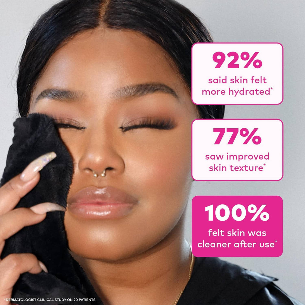 Black MakeUp Eraser cloth pressed to cheek for makeup removal, close-up.