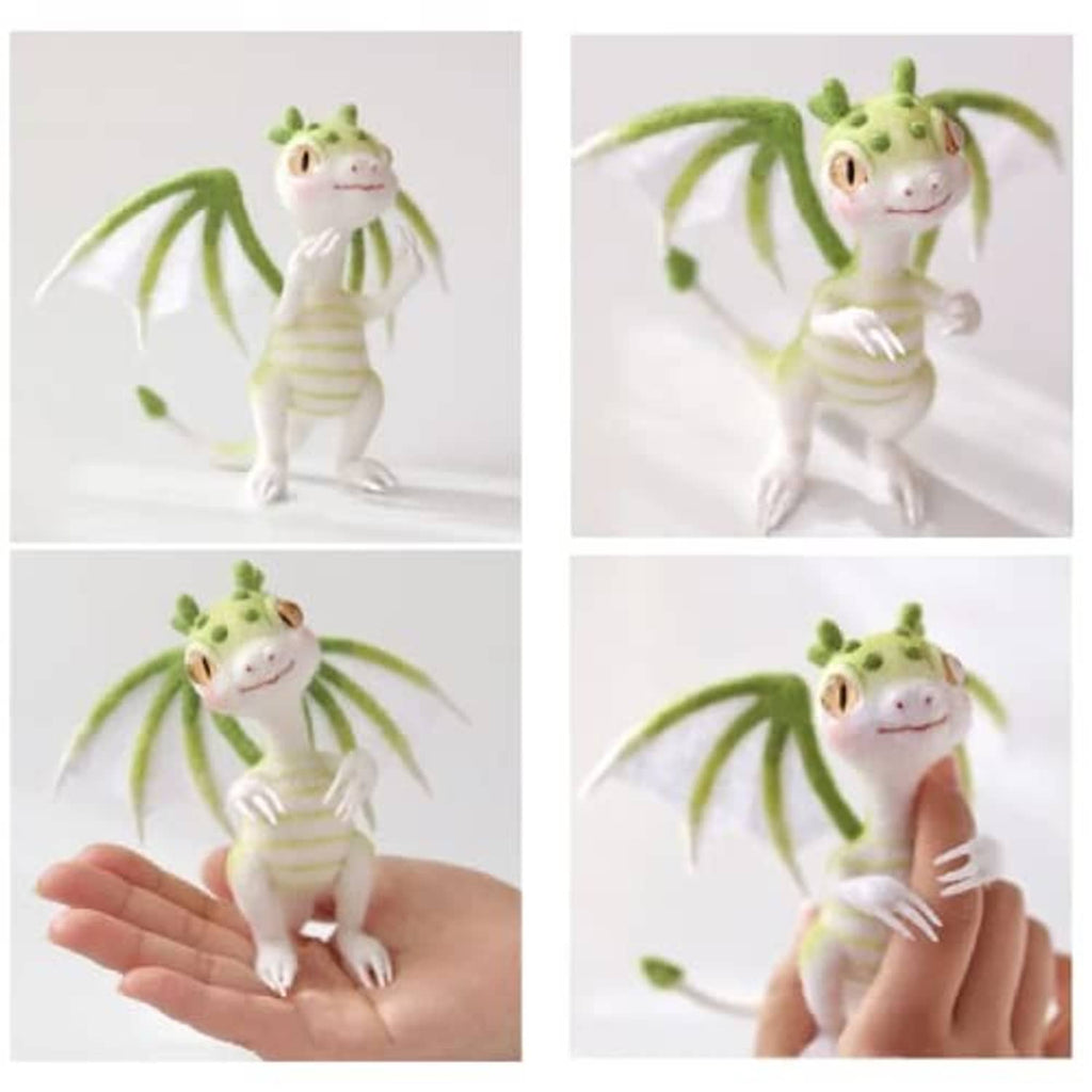 Felt dragon figurine with green wings and striped body, posed and held in hands