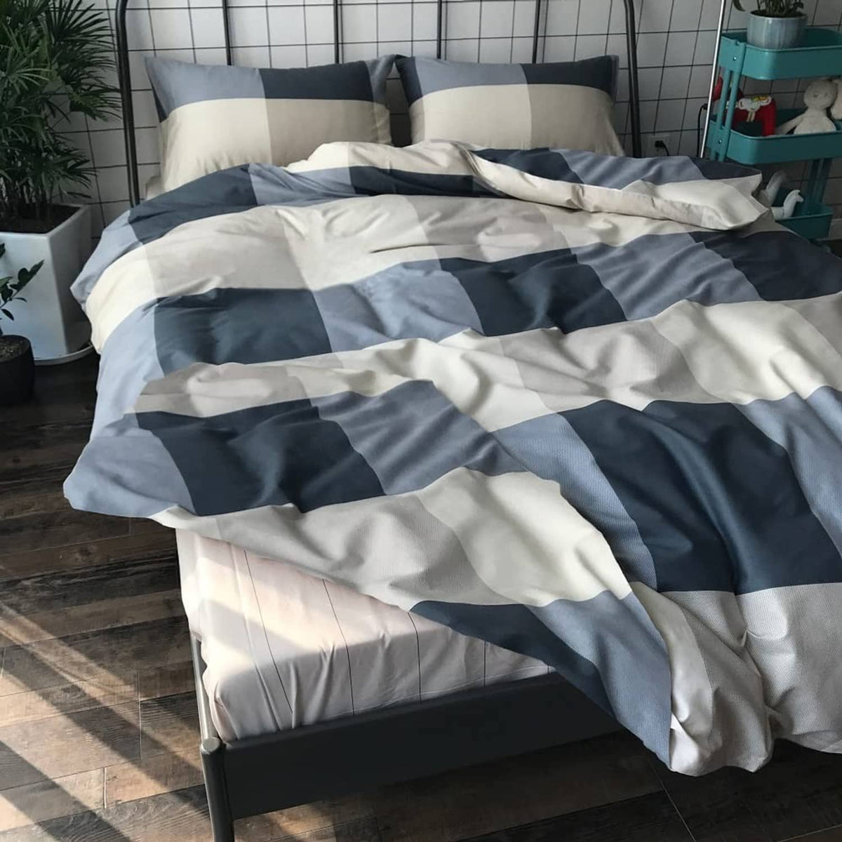 Comforter set with navy and white check pattern bedding in neat layers