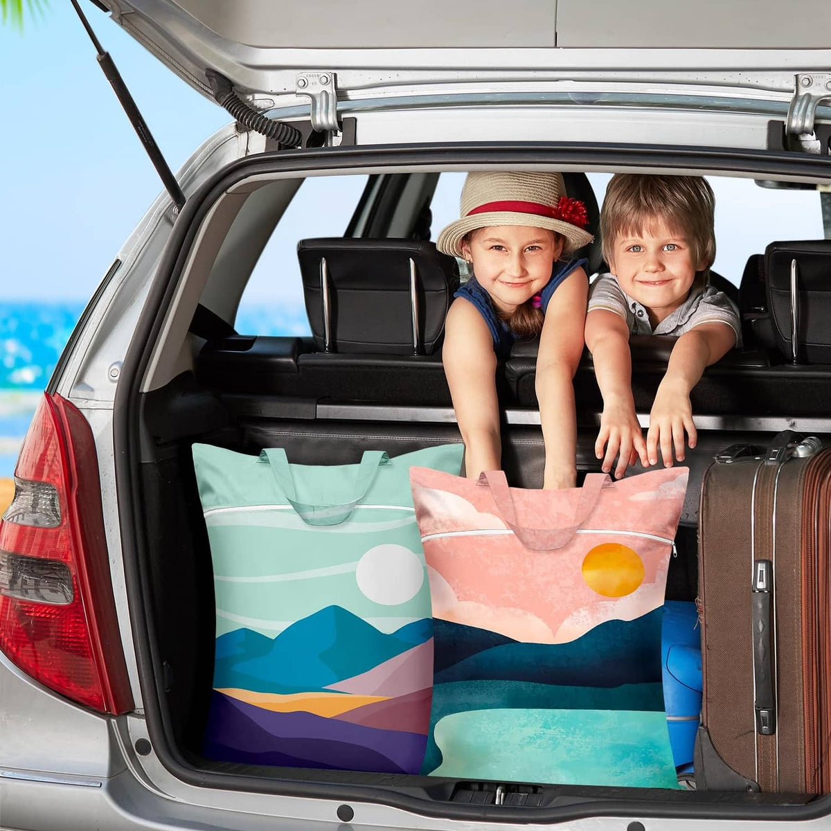 Pair of mint and pink landscape laundry bags with handles in a car trunk