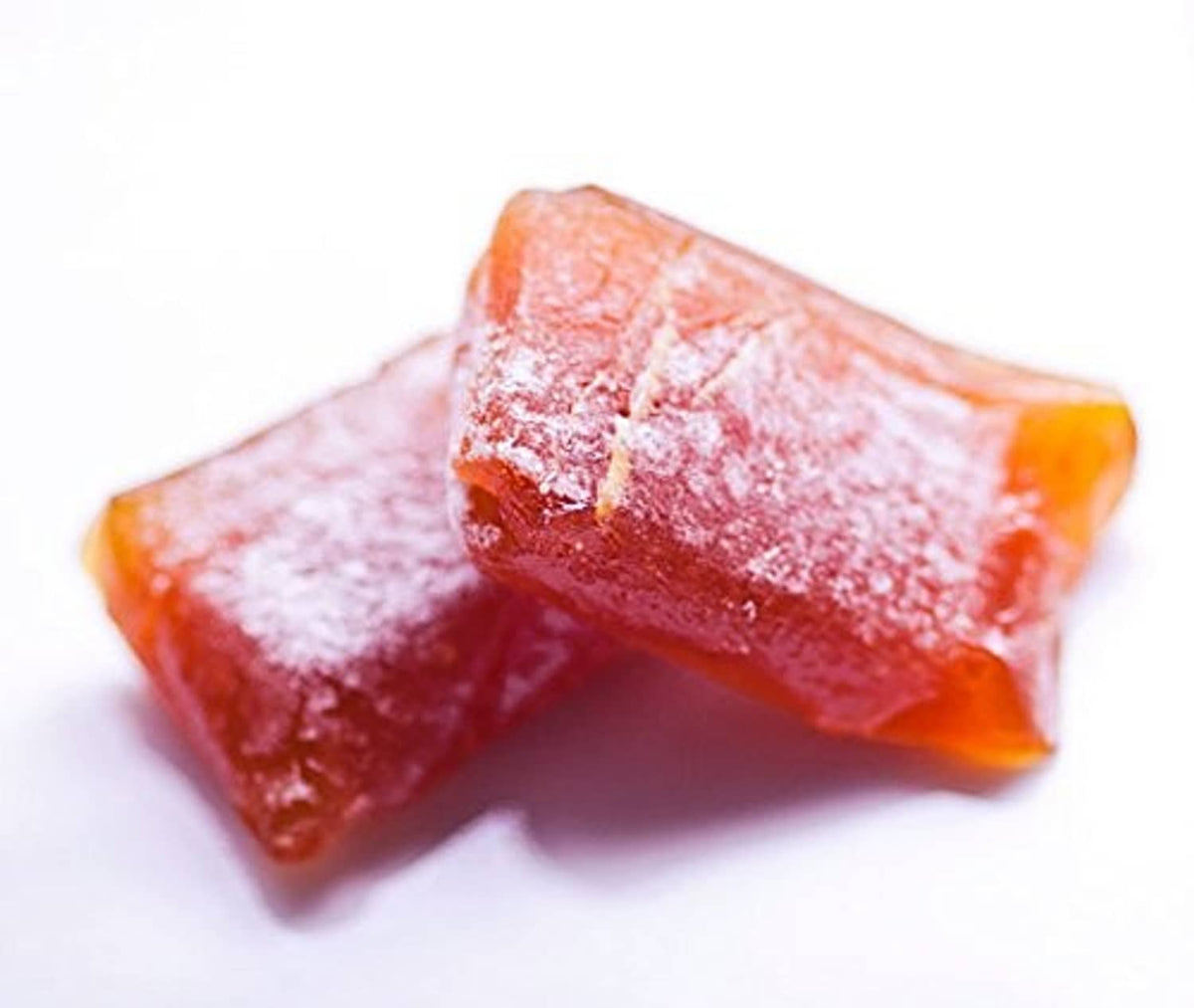 Chewy ginger candy pieces, glossy red-orange sugar-coated chews