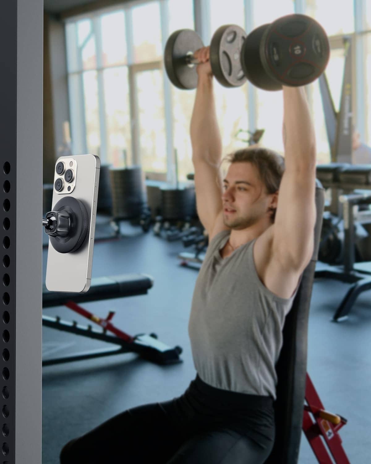 Black magnetic phone holder mounted on gym weight machine with phone attached