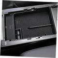 Dark textured armrest cover insert with storage compartments and side slot