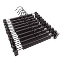 Black pants hanger set with adjustable clips and curved anti-slip grips on a bar