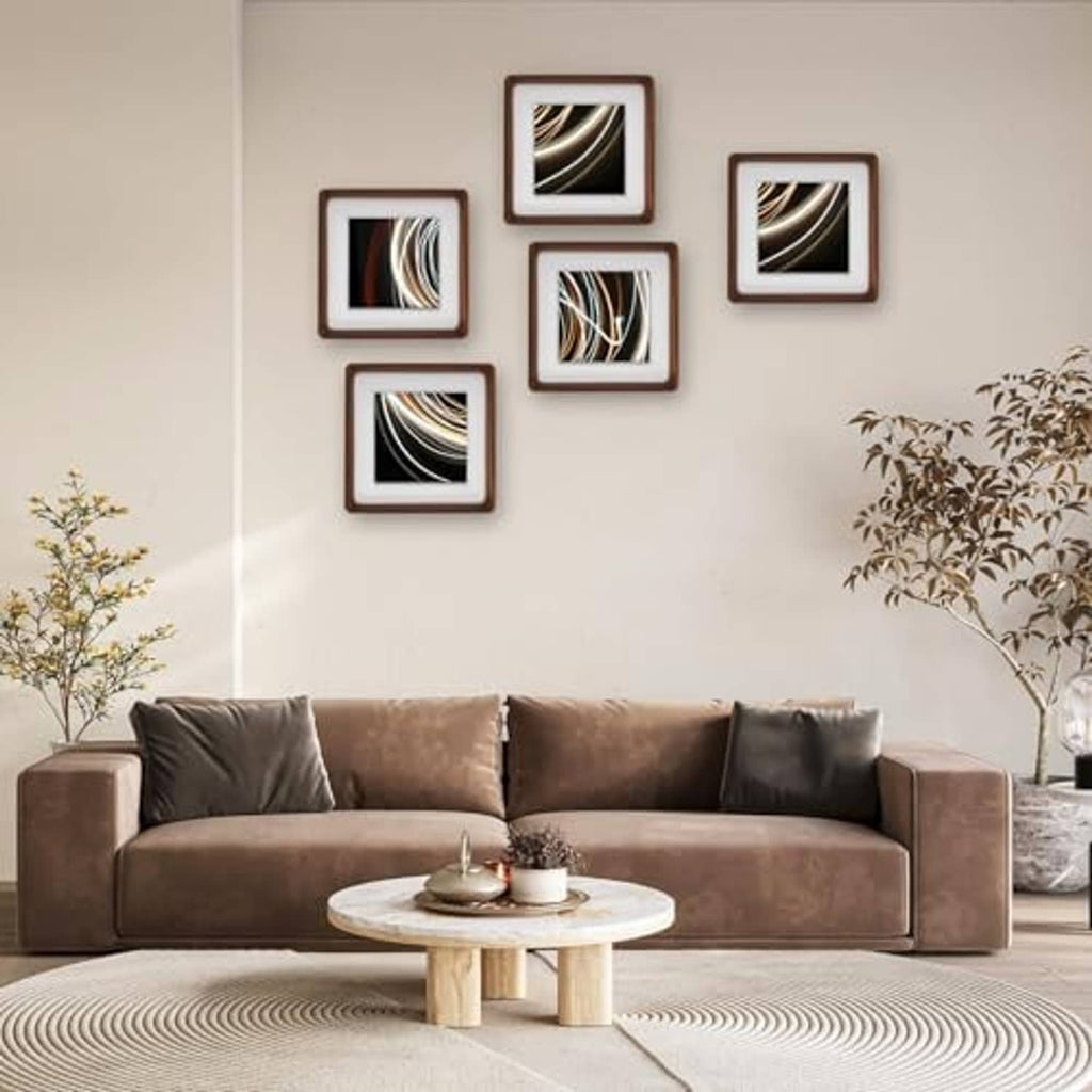 Group of small walnut wood picture frames with white mats on a wall.