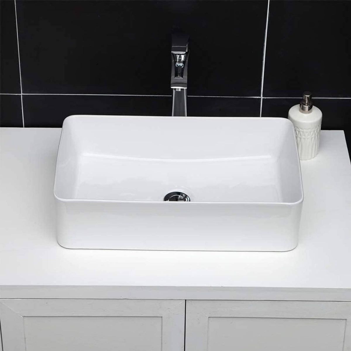 White rectangular bathroom vessel sink with drain opening and chrome faucet