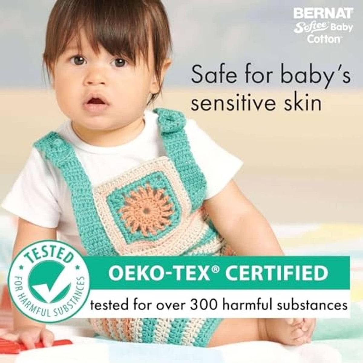 Baby wearing a turquoise knit vest with a square crocheted motif