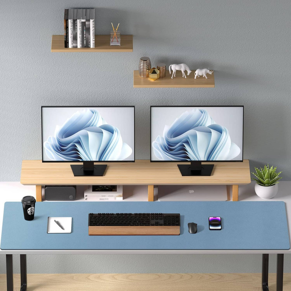 Denim blue desk pad protector on desk with keyboard, phone, and office items