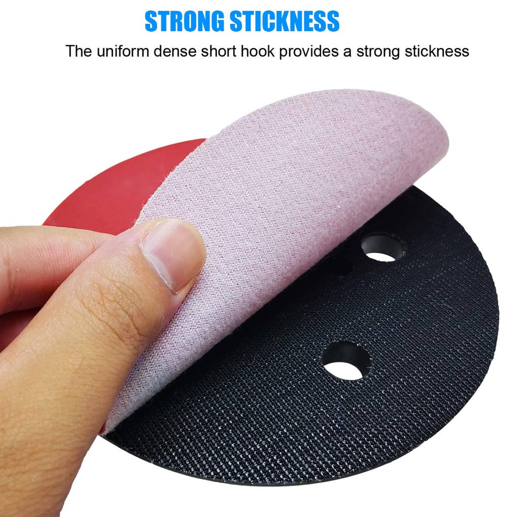Hook-and-loop sanding pad with pink top layer and black backing ring, dust holes shown