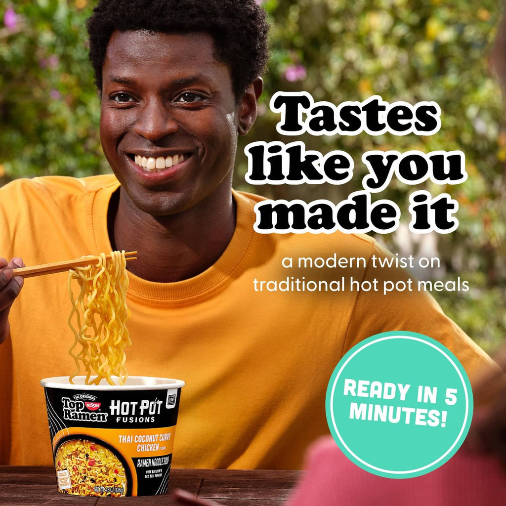 Hot Pot Fusions ramen cup with noodles, Thai coconut curry chicken flavor, held by person