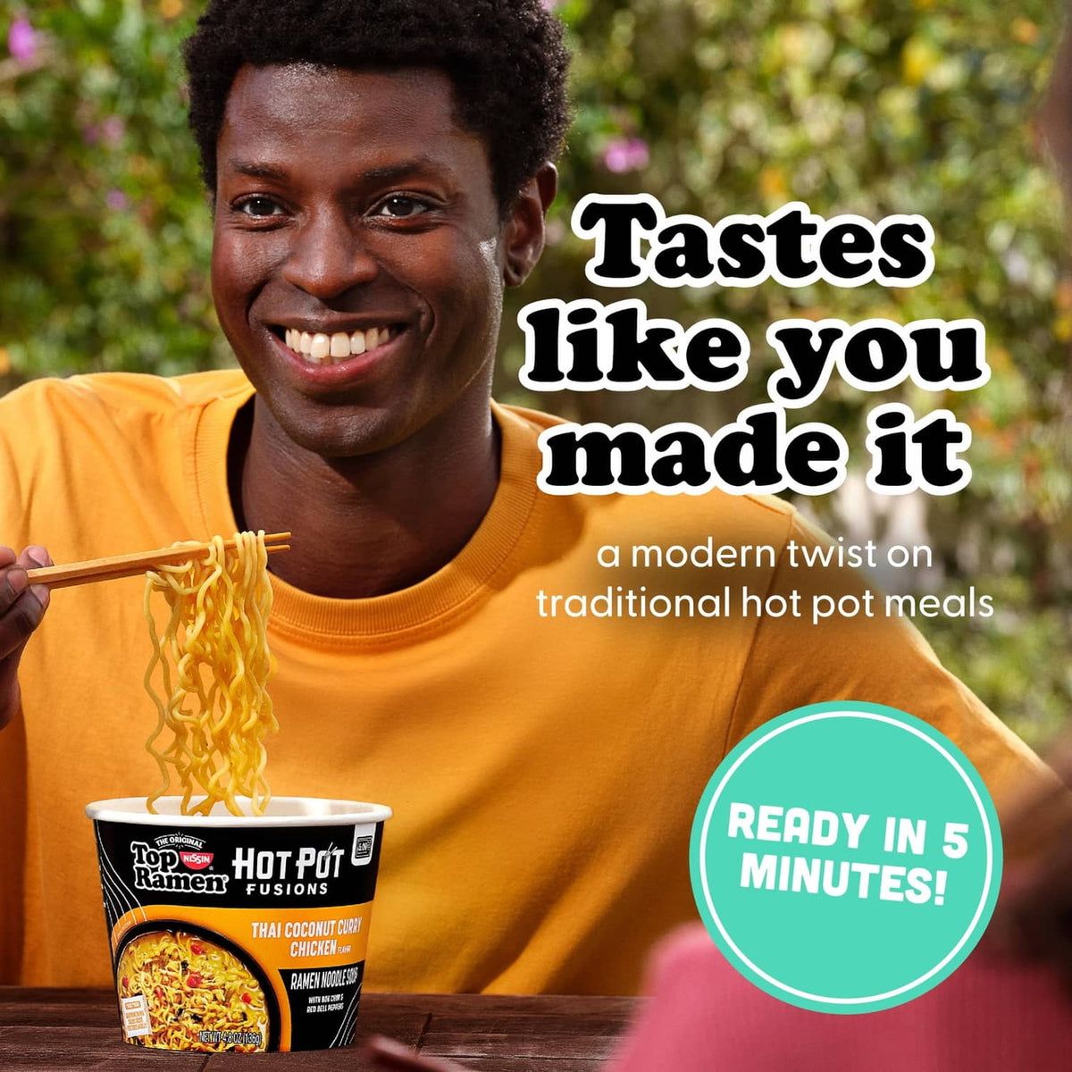 Hot Pot Fusions ramen cup with noodles, Thai coconut curry chicken flavor, held by person