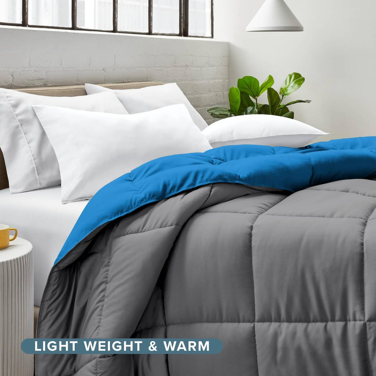 Twin XL reversible comforter draped with blue cover and grey reverse on bed