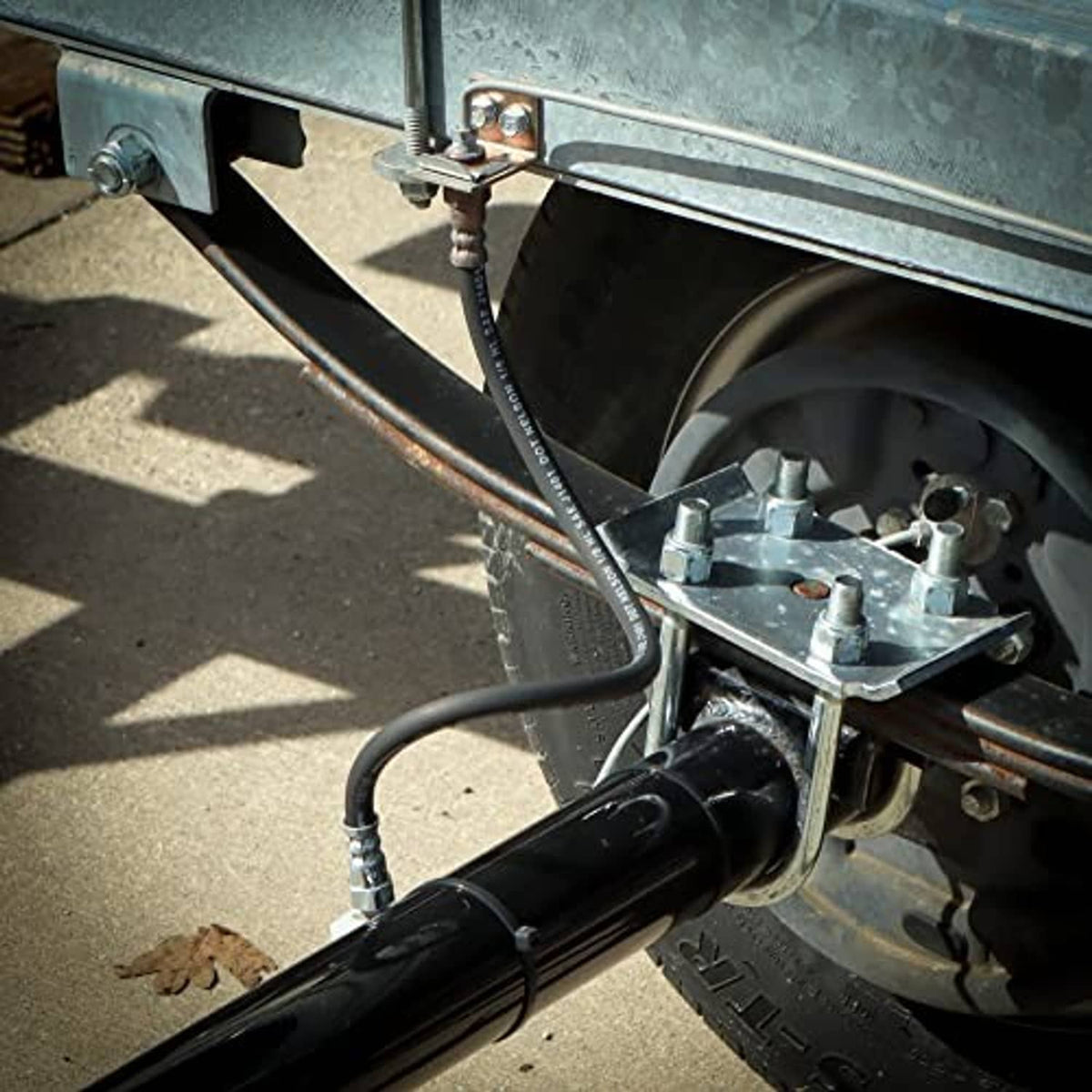 Brake hose routed near the wheel with black rubber line and metal swivel connectors