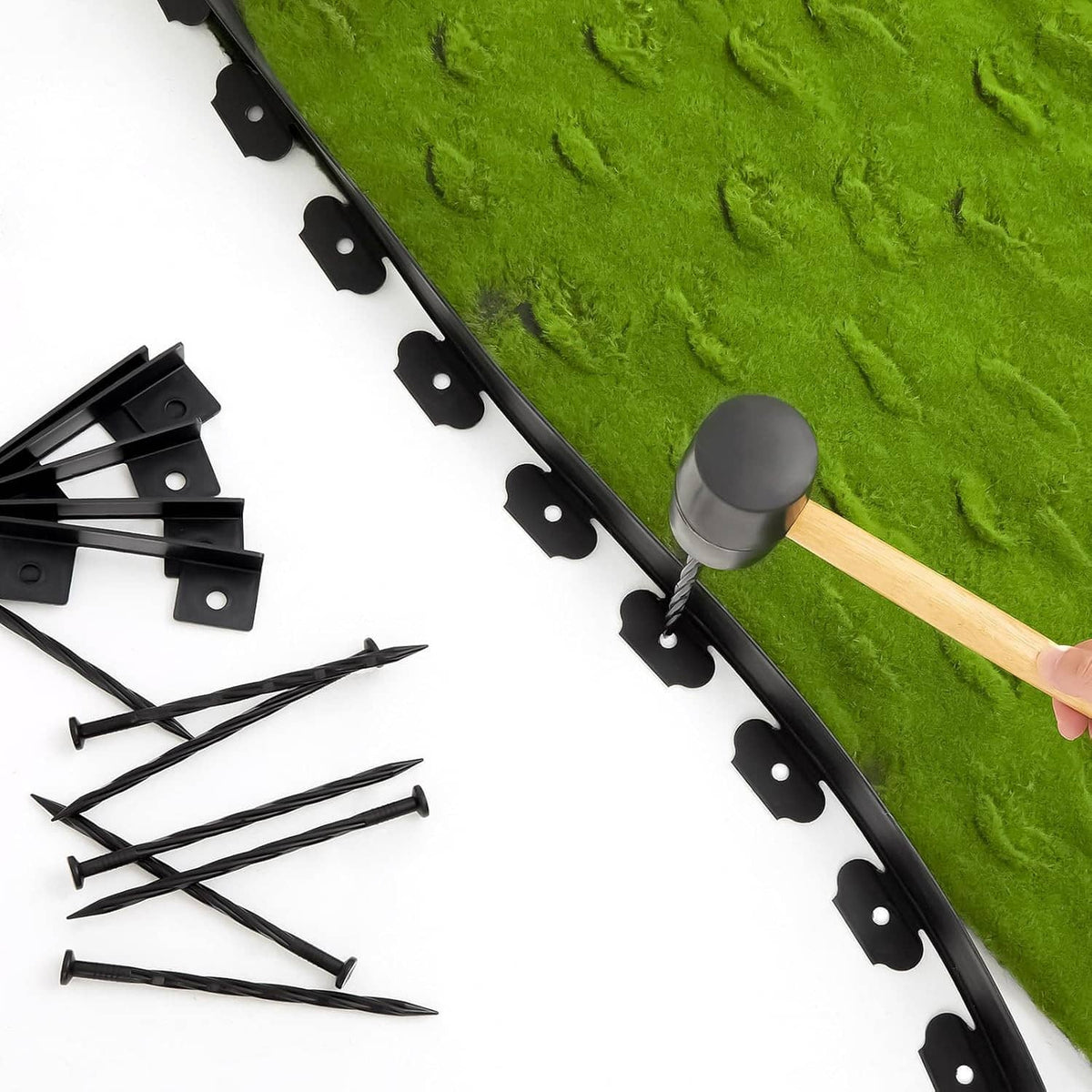Black landscape edging strip with anchor spikes, plus metal brackets and stakes laid out.