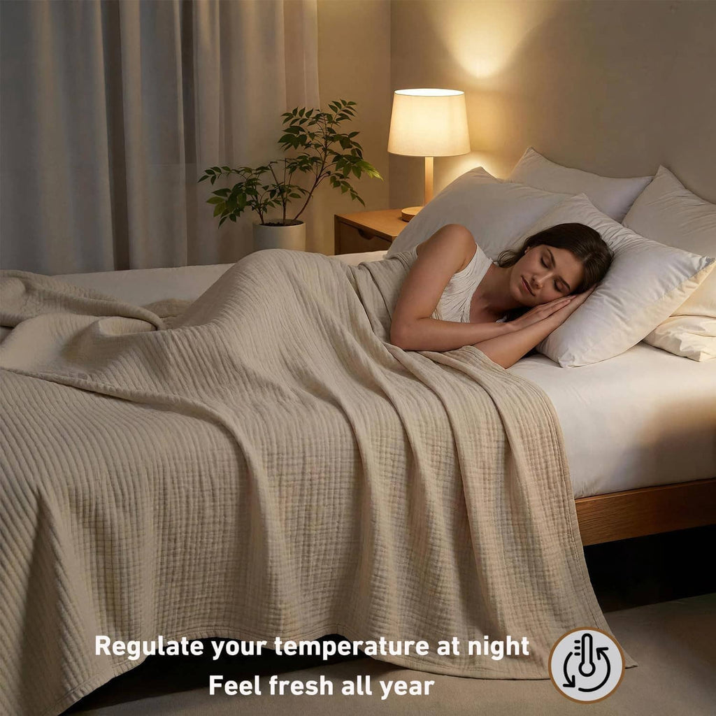 Cream muslin blanket covering a person on a bed, folded in soft draped layers.