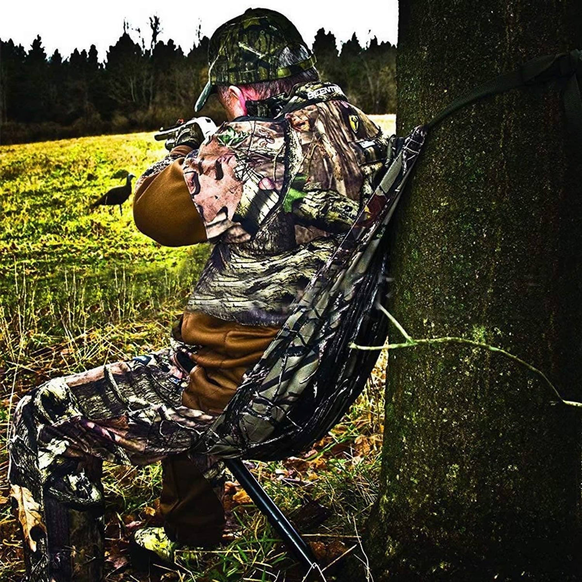 Camouflage hammock-style camping chair suspended from a tree trunk