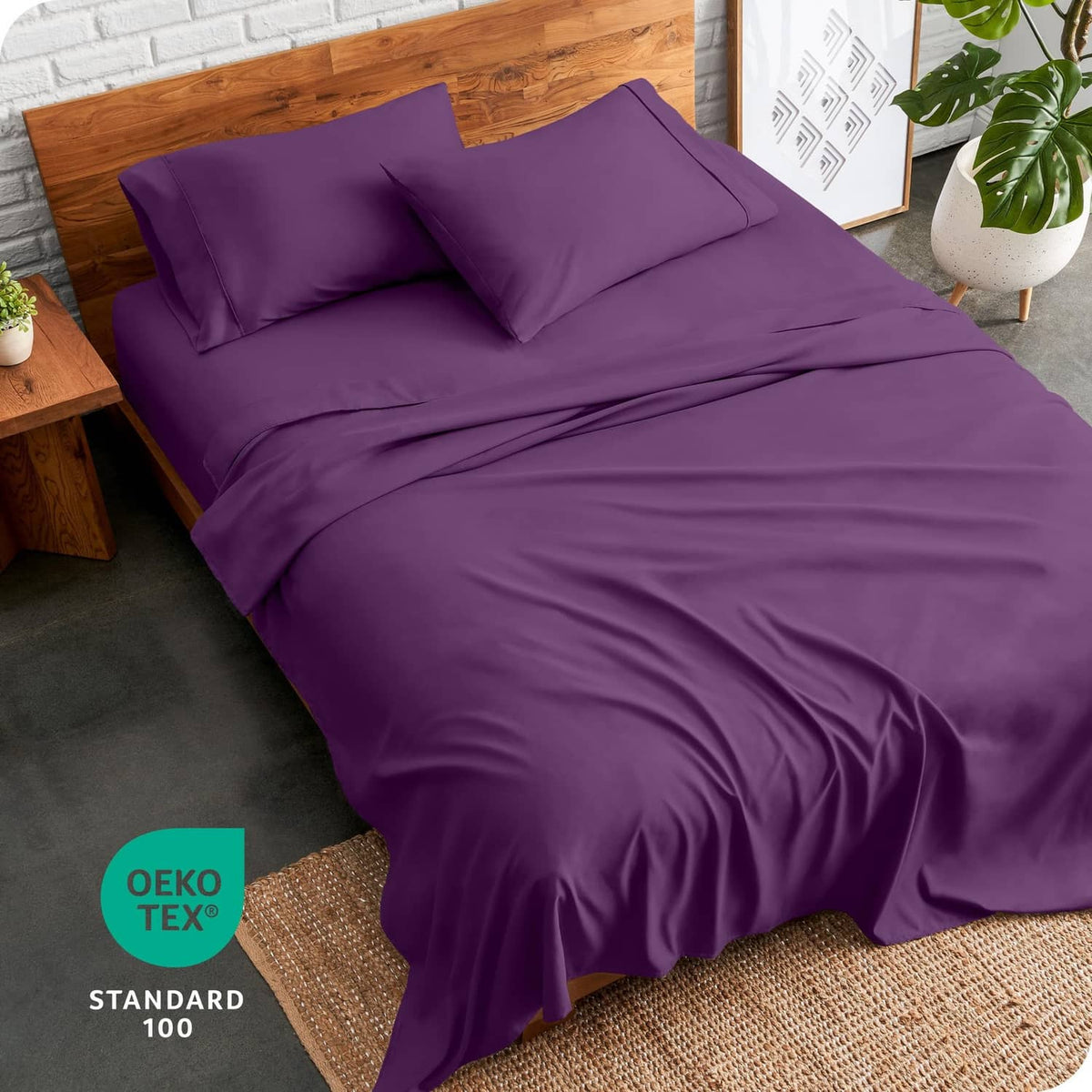 Plum twin bed sheet set with fitted sheet and two pillowcases on a wood bed frame