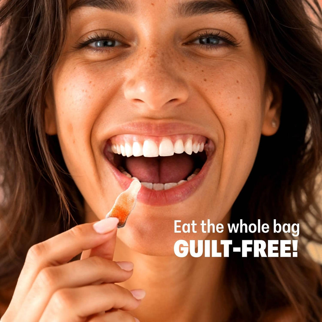 Woman holding a low-sugar candy piece, smiling with an open-mouth bite