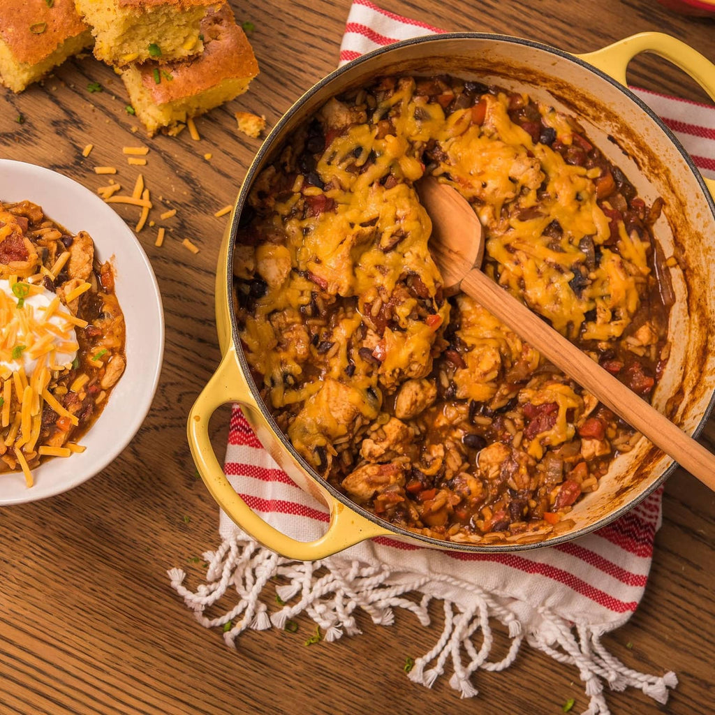 Tray and pot of black beans and rice with wooden spoon, plus side serving plate