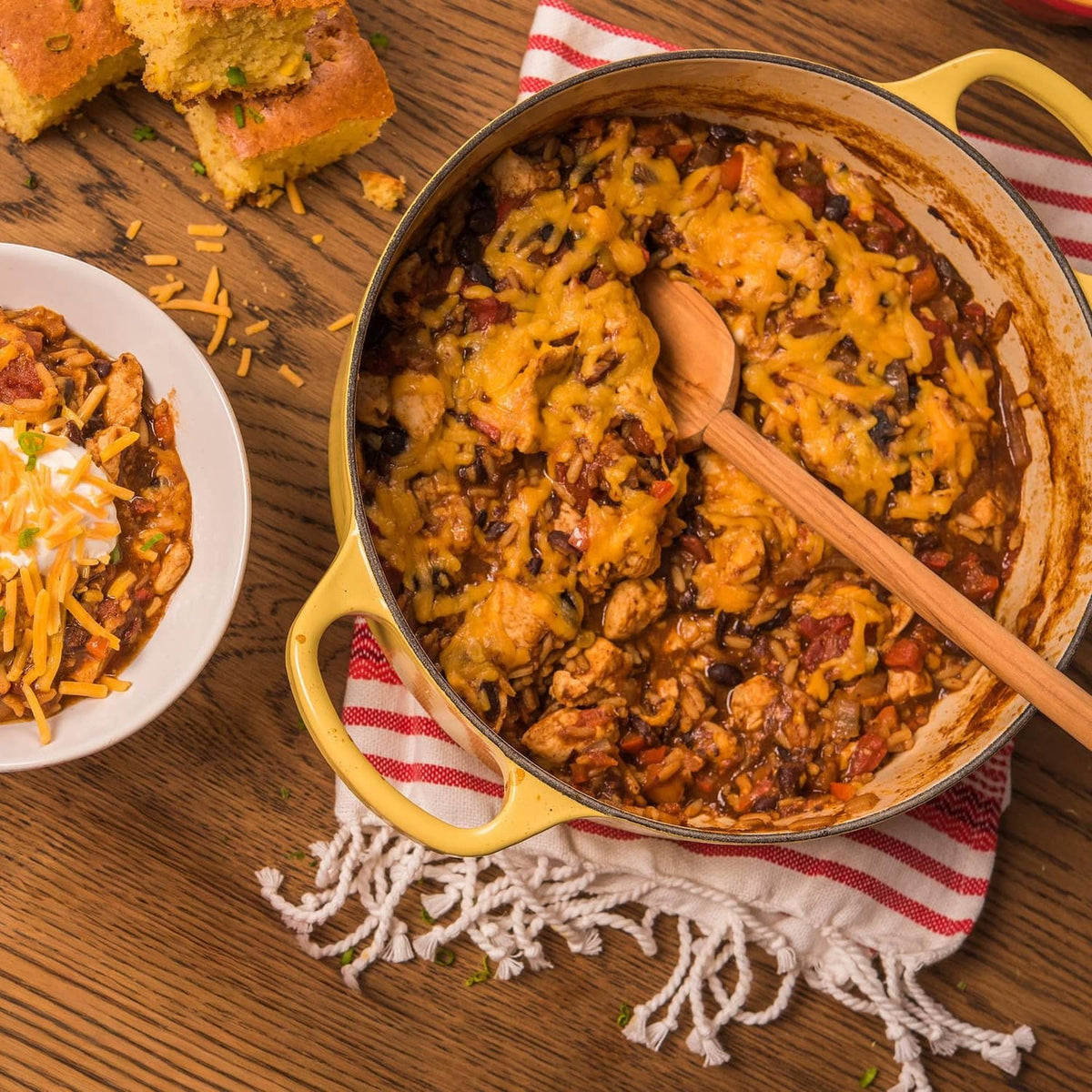 Tray and pot of black beans and rice with wooden spoon, plus side serving plate