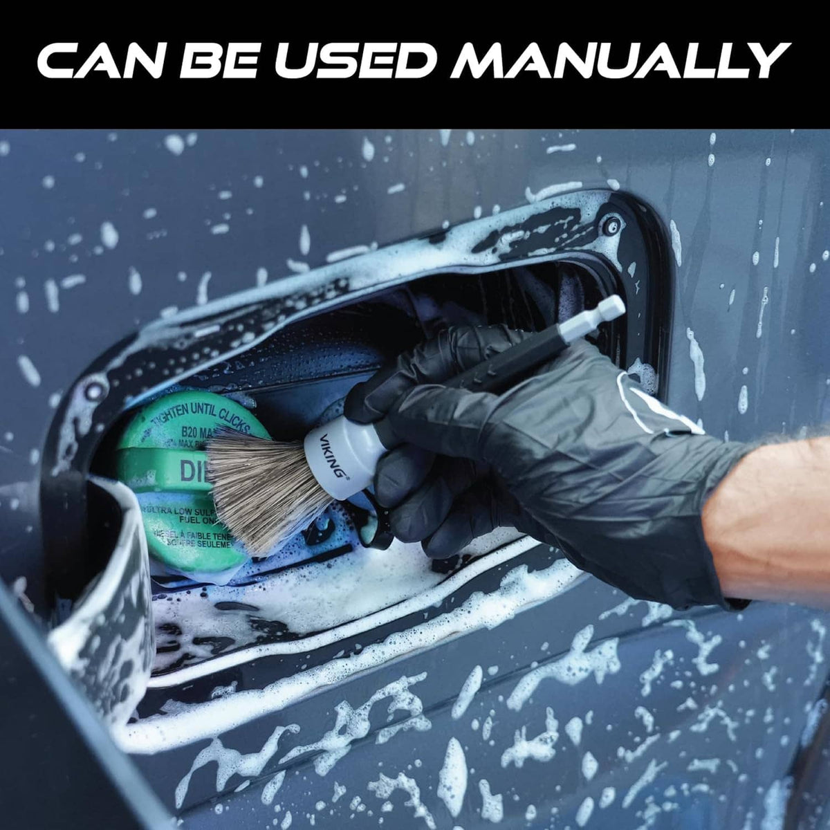Hand using a drill detail brush on a car interior panel