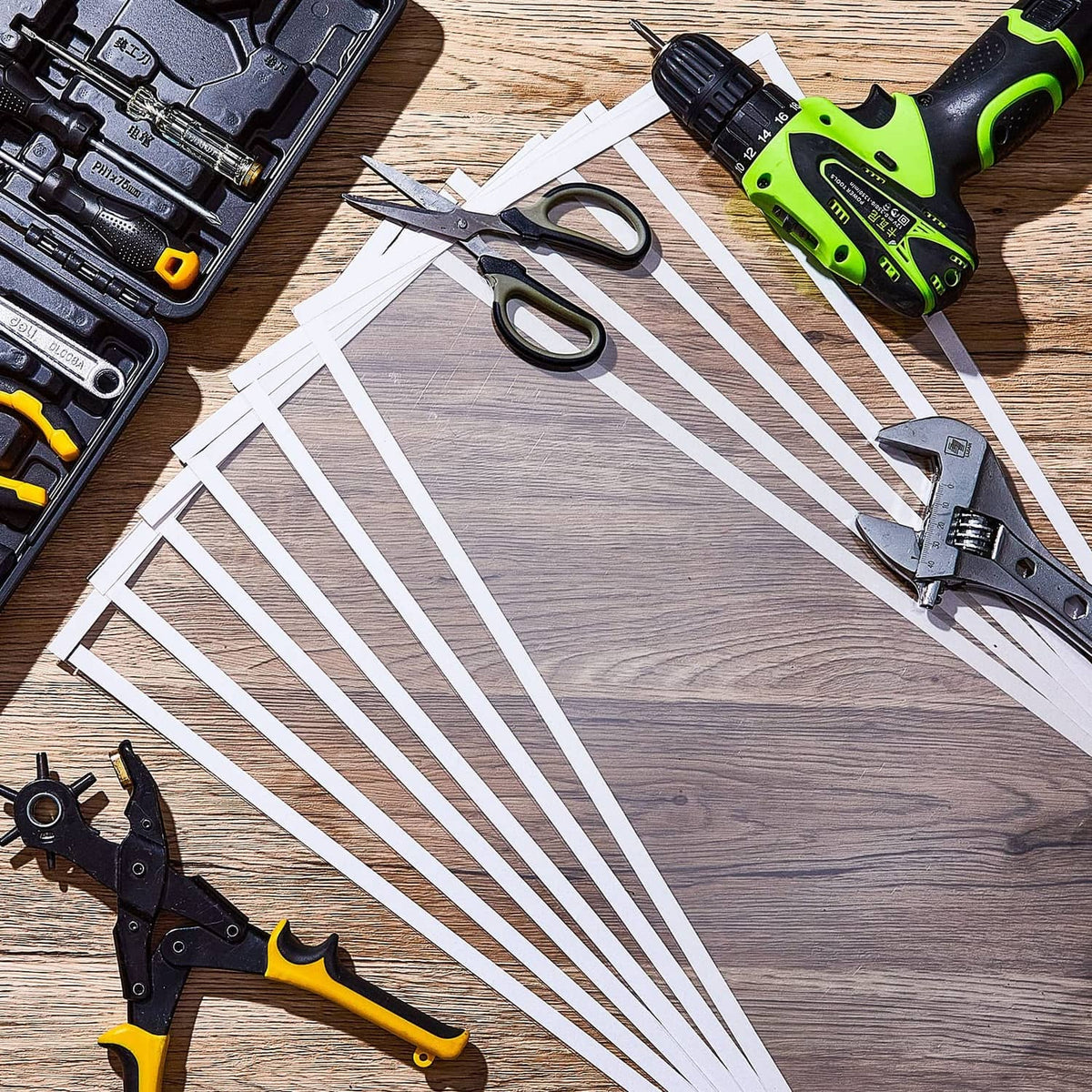Rectangular clear blast cabinet lens protector sheets laid out with tools on a wooden table
