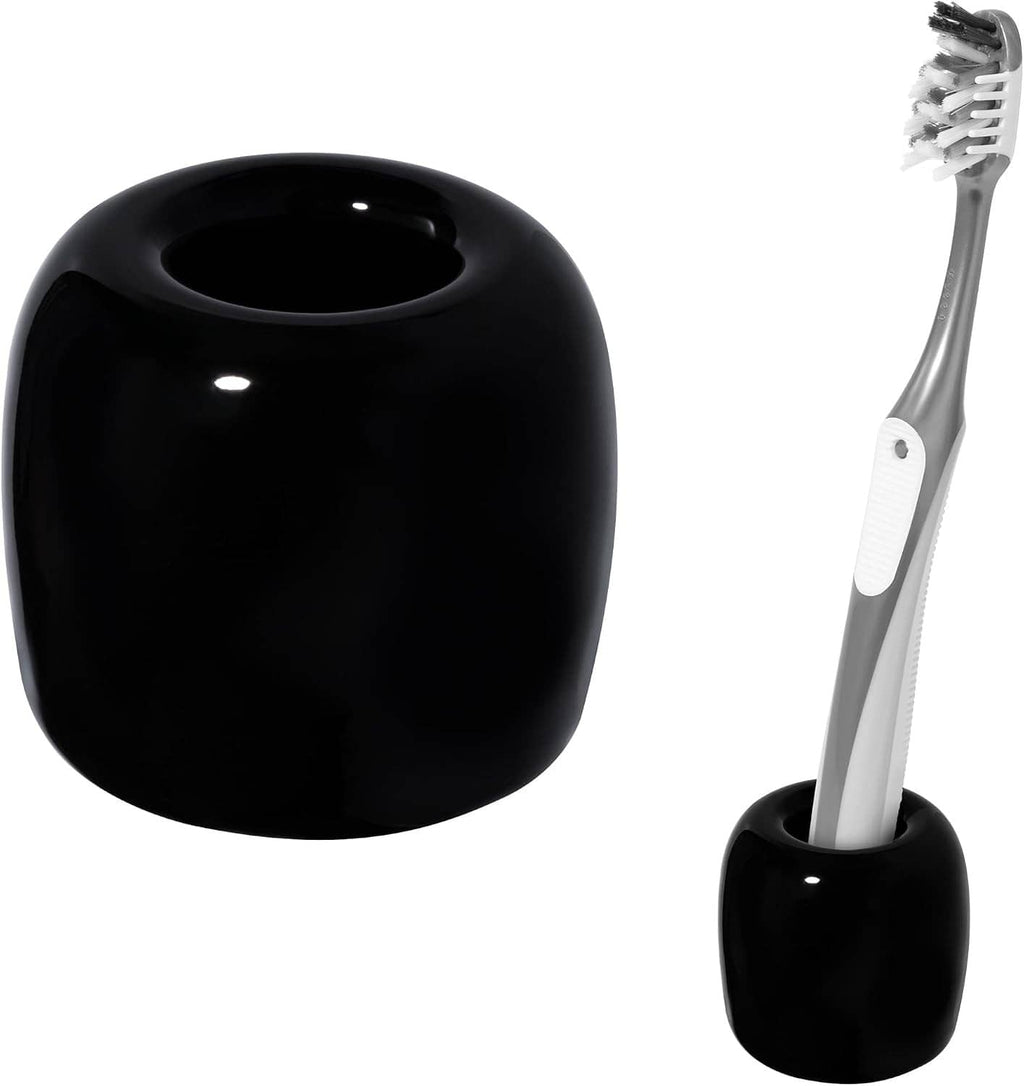 Black ceramic toothbrush holder cup with toothbrush inserted