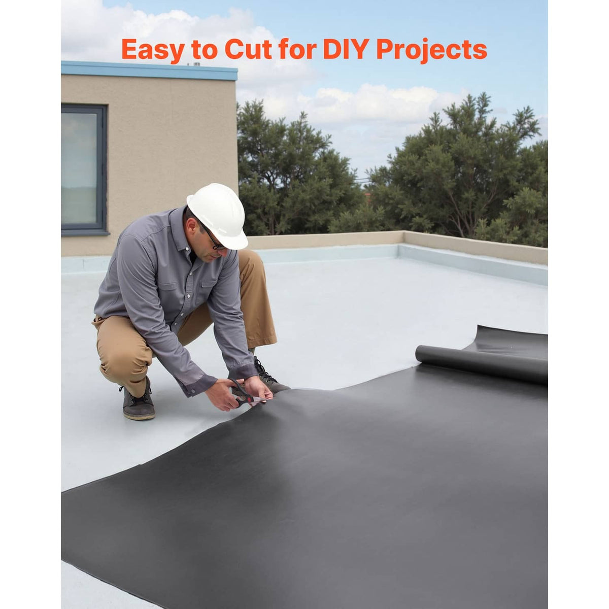 Person installing black EPDM rubber roofing membrane on a flat rooftop