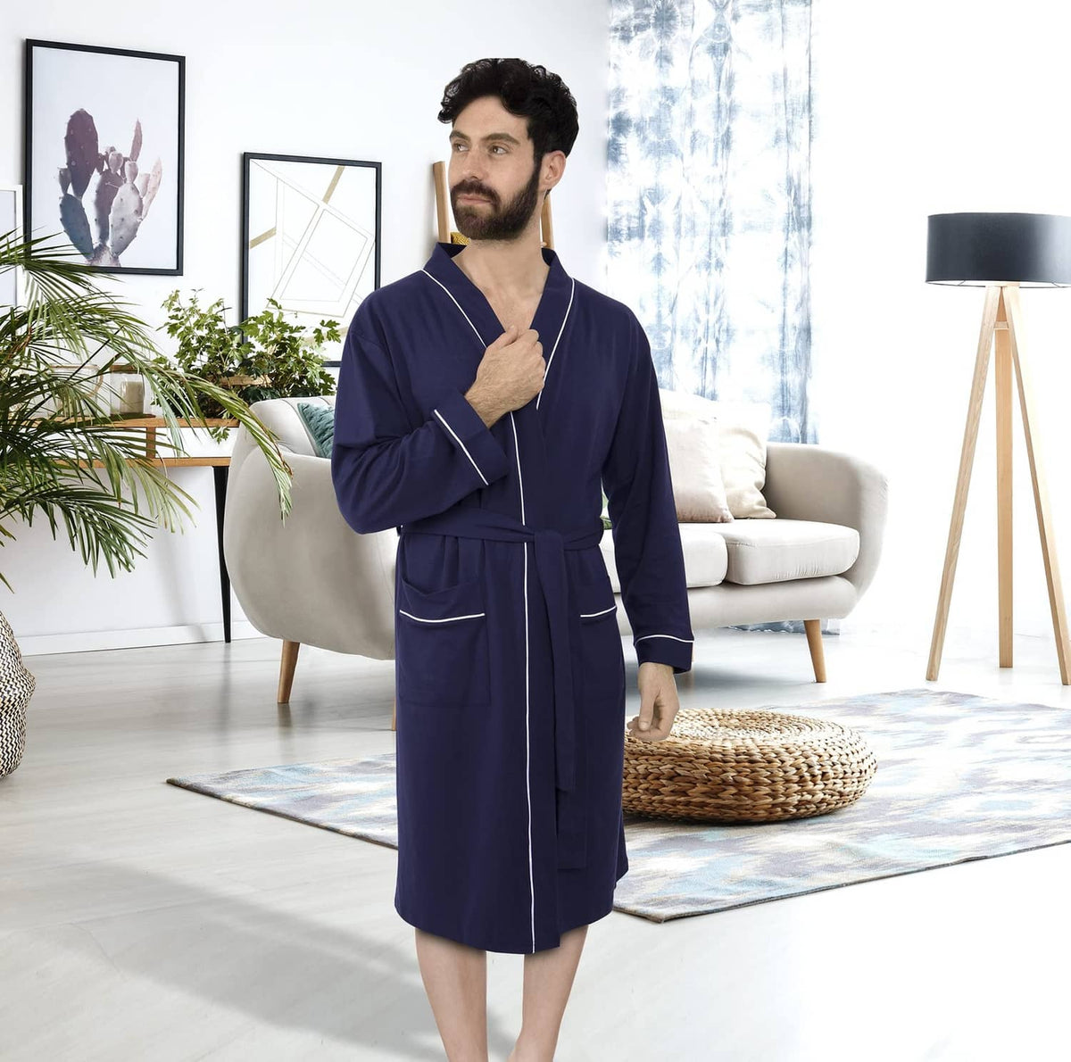 Men’s navy knit bathrobe with shawl collar and belt tie, standing in living room.
