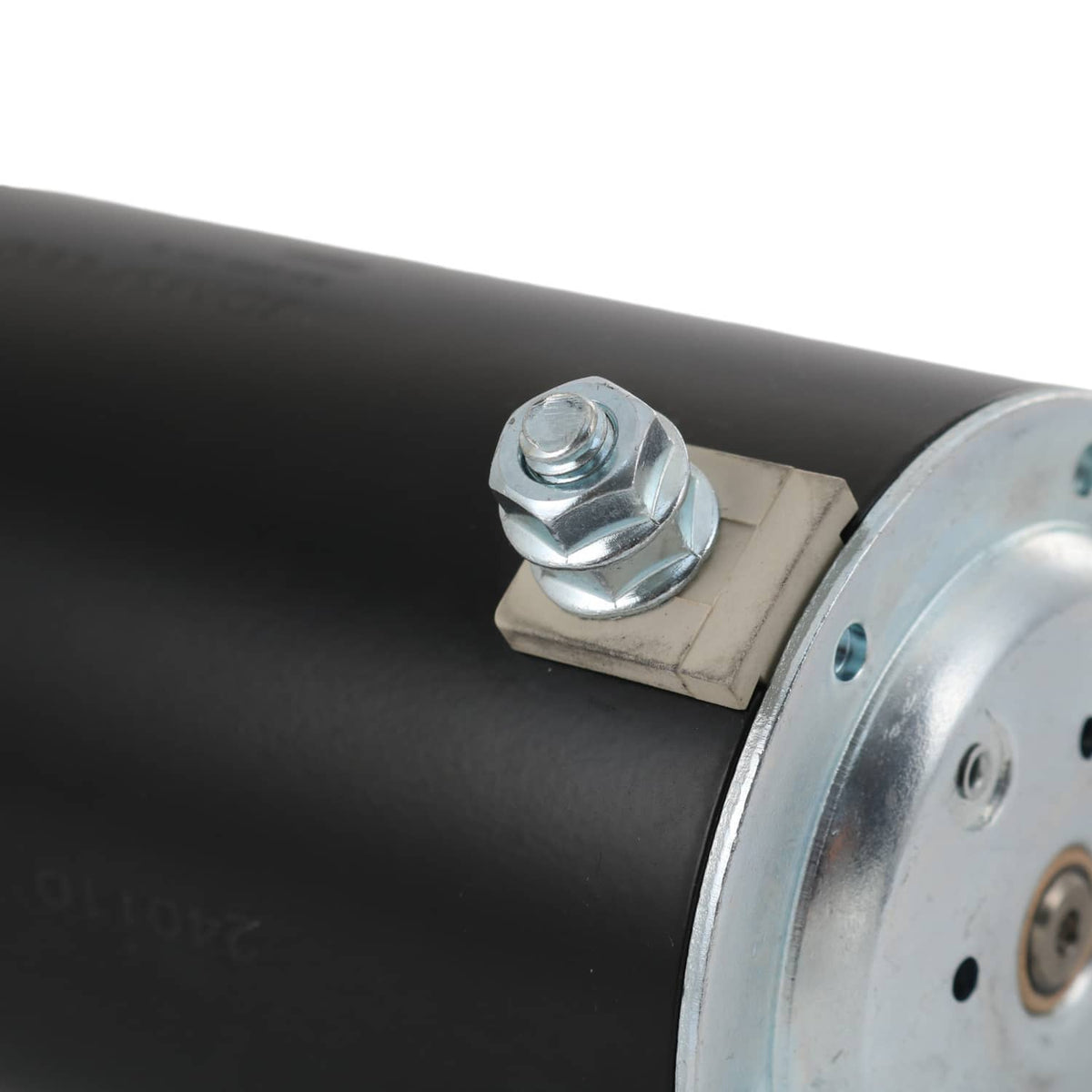 Starter motor housing close-up with black cylinder and silver terminal bracket
