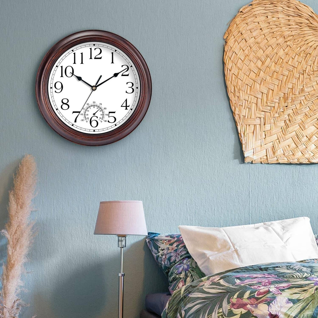 Outdoor wall clock with copper-red frame and thermometer dial, shown on a wall near bedding.