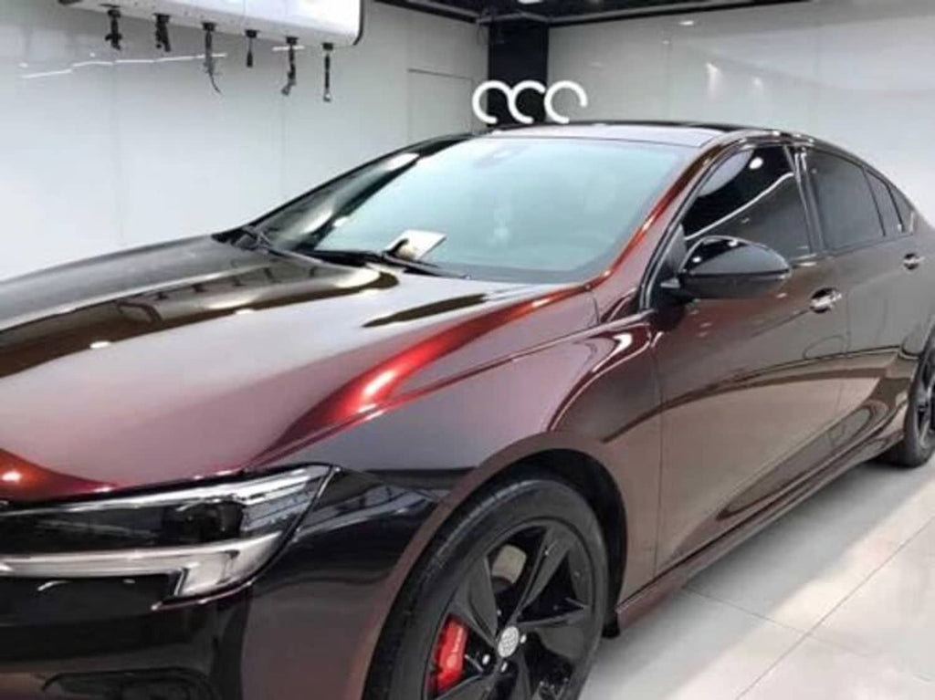 Gloss chrome black-to-red car wrap vinyl on sedan hood, indoor showroom angle