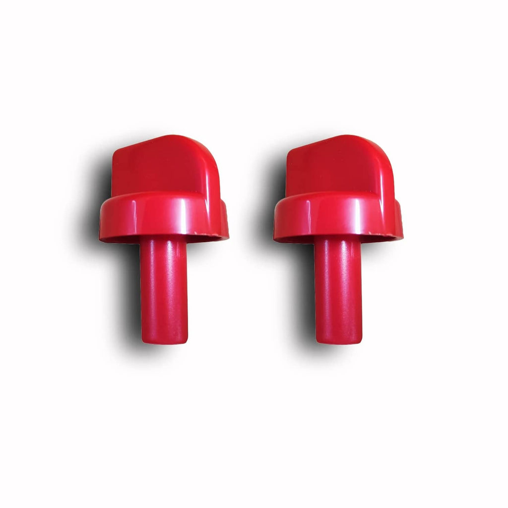 Two red plastic control valve knobs side by side, domed caps and stems