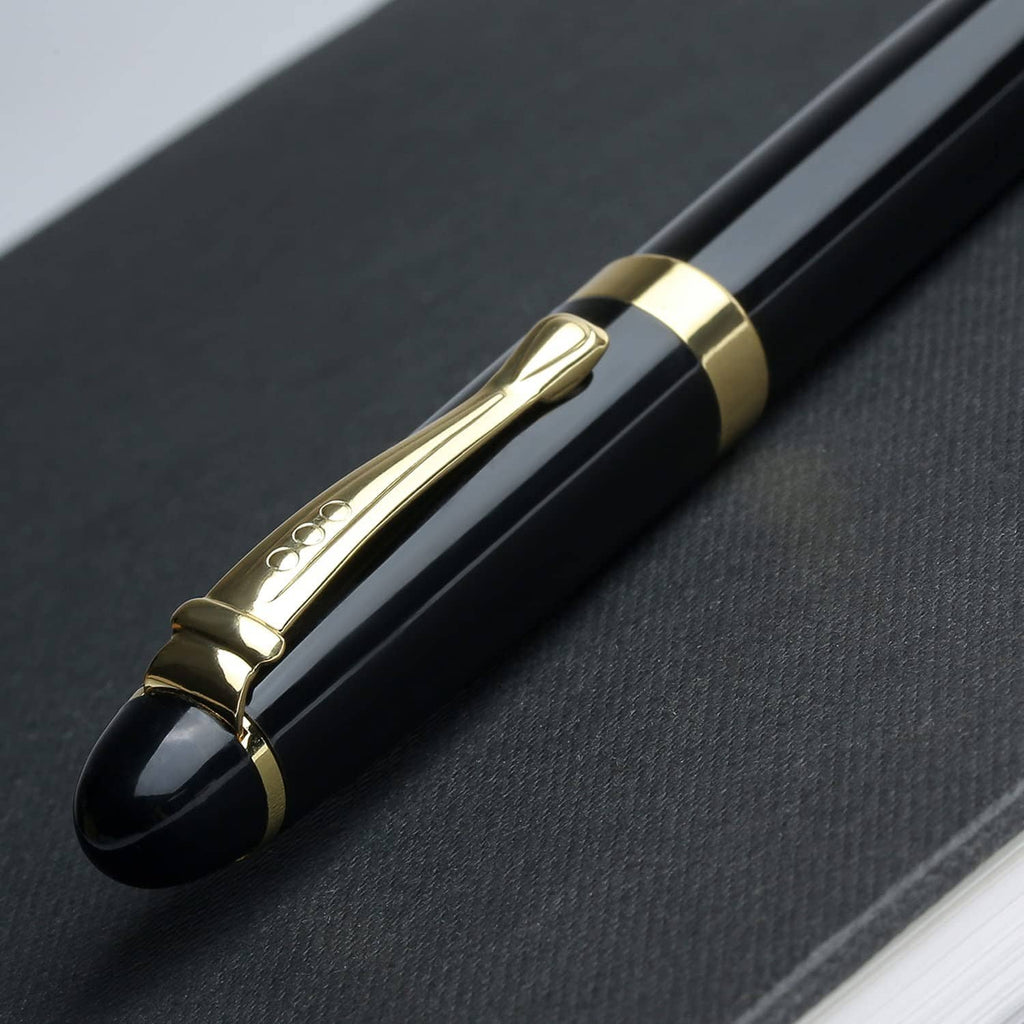 Black luxury ballpoint pen close-up of the gold band and engraved center