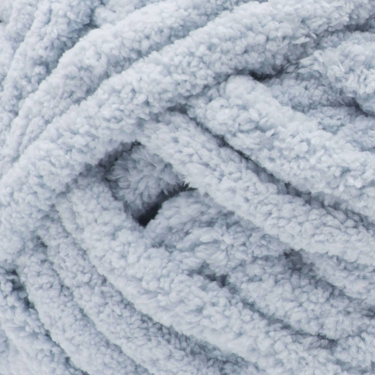 Close-up of light blue chenille-style chunky yarn with looped texture