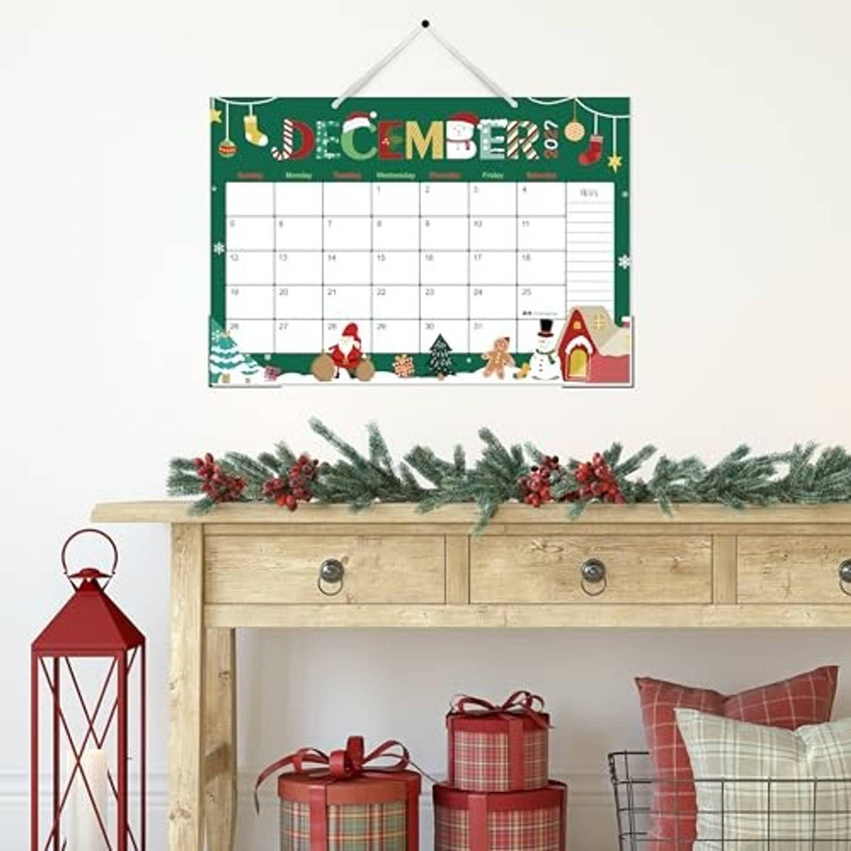 Green December 2026 desk calendar hanging display with date grid and holiday decorations