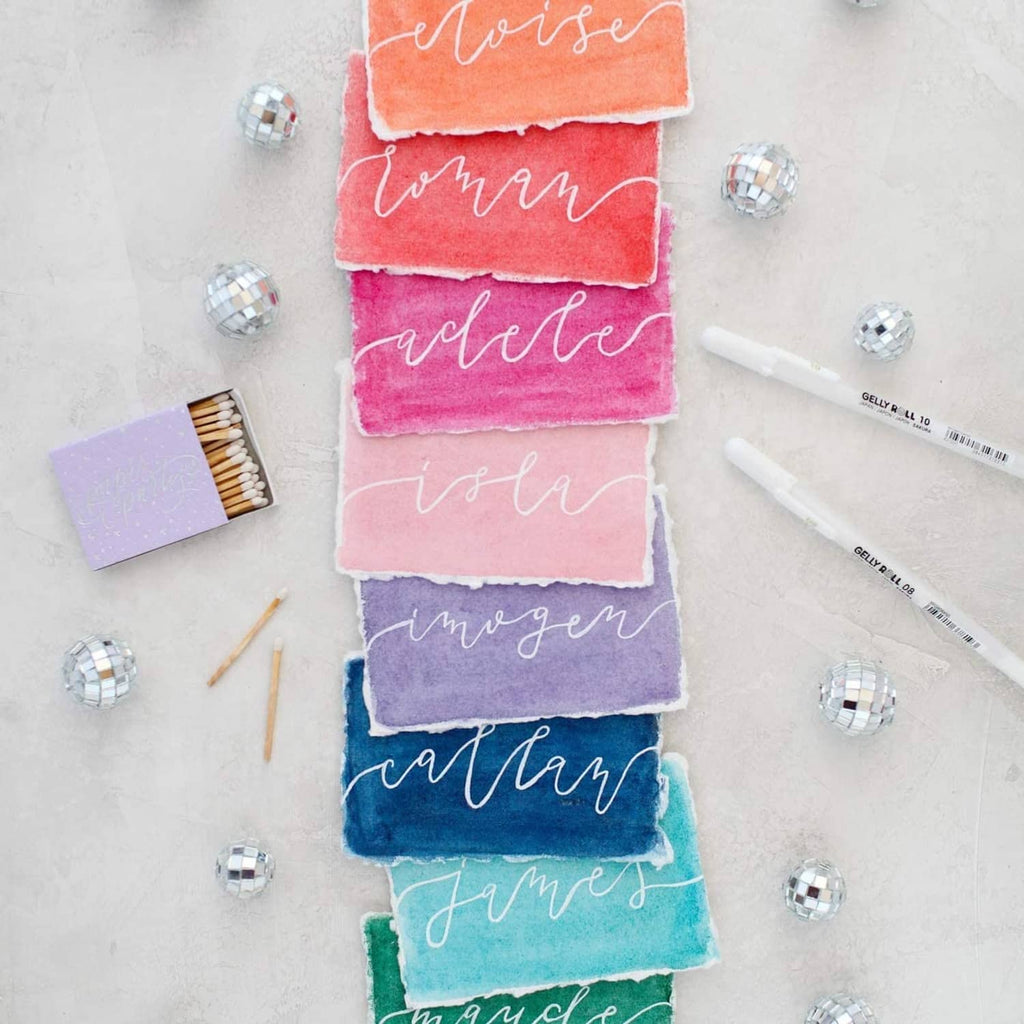 White ink gel pens with opaque writing on colorful paper swatches.