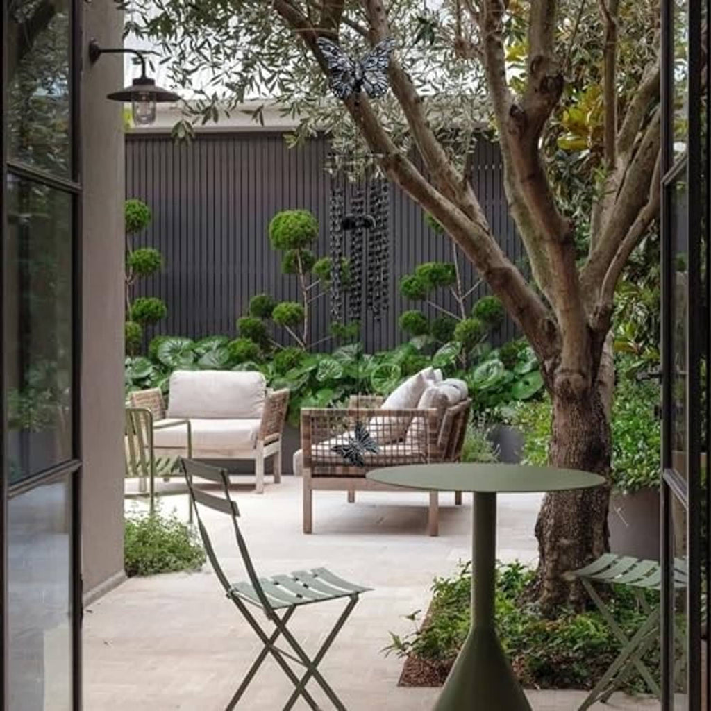Black and white butterfly wind chime hanging outdoors above garden seating